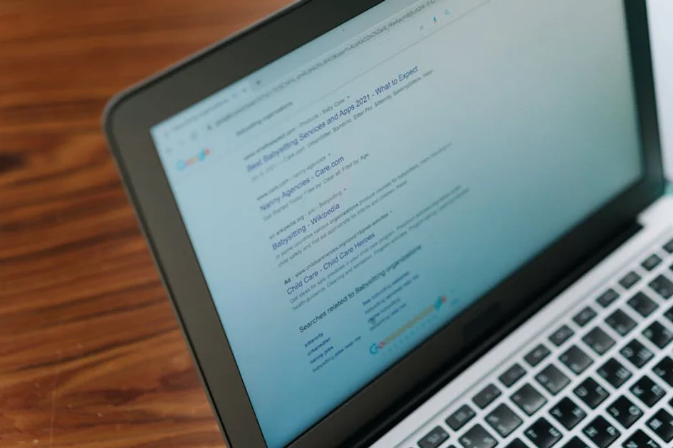 Laptop on a wooden desk showing a page of Google search results
